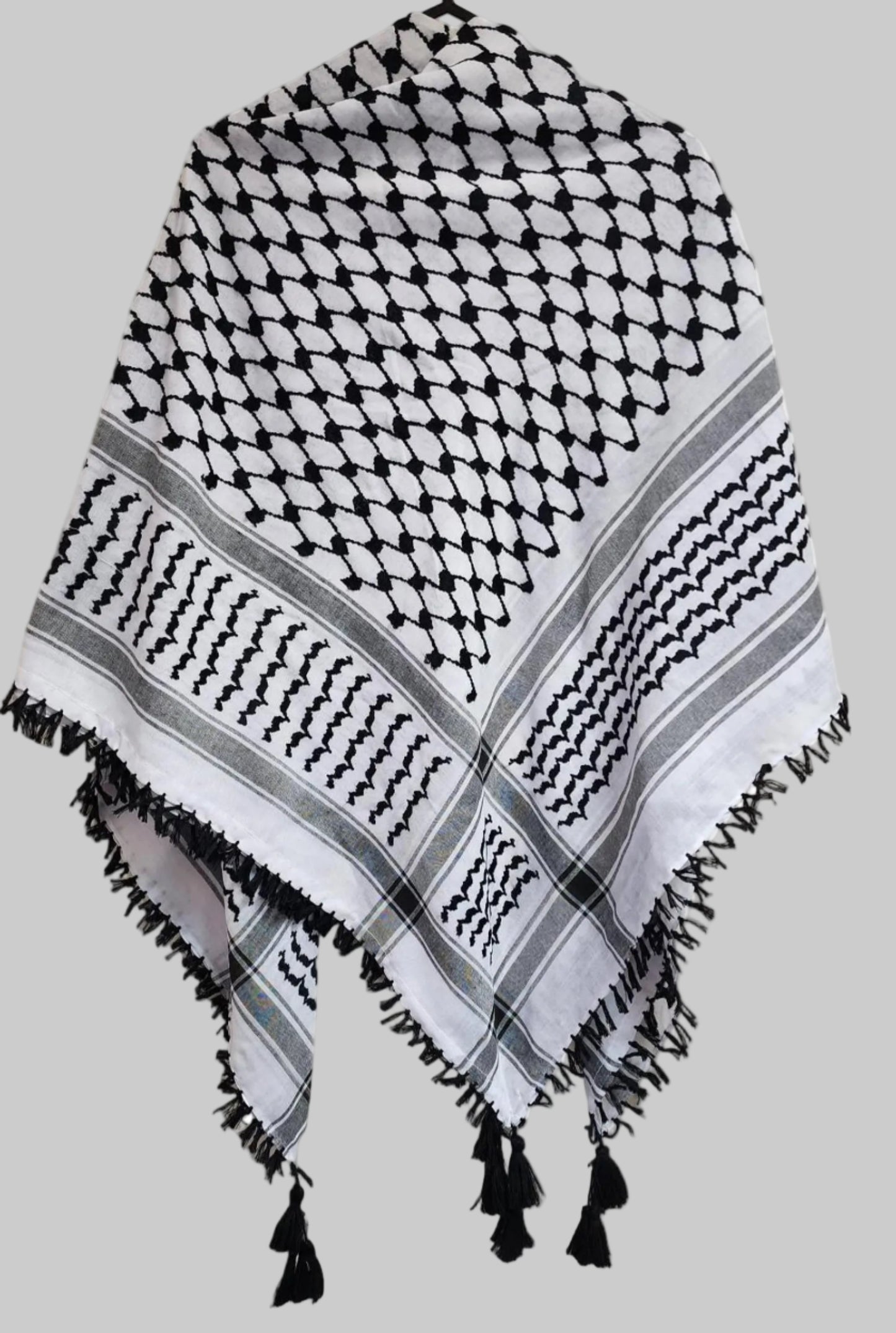 alt="Black and white Palestinian keffiyeh scarf laid flat showing traditional woven pattern"