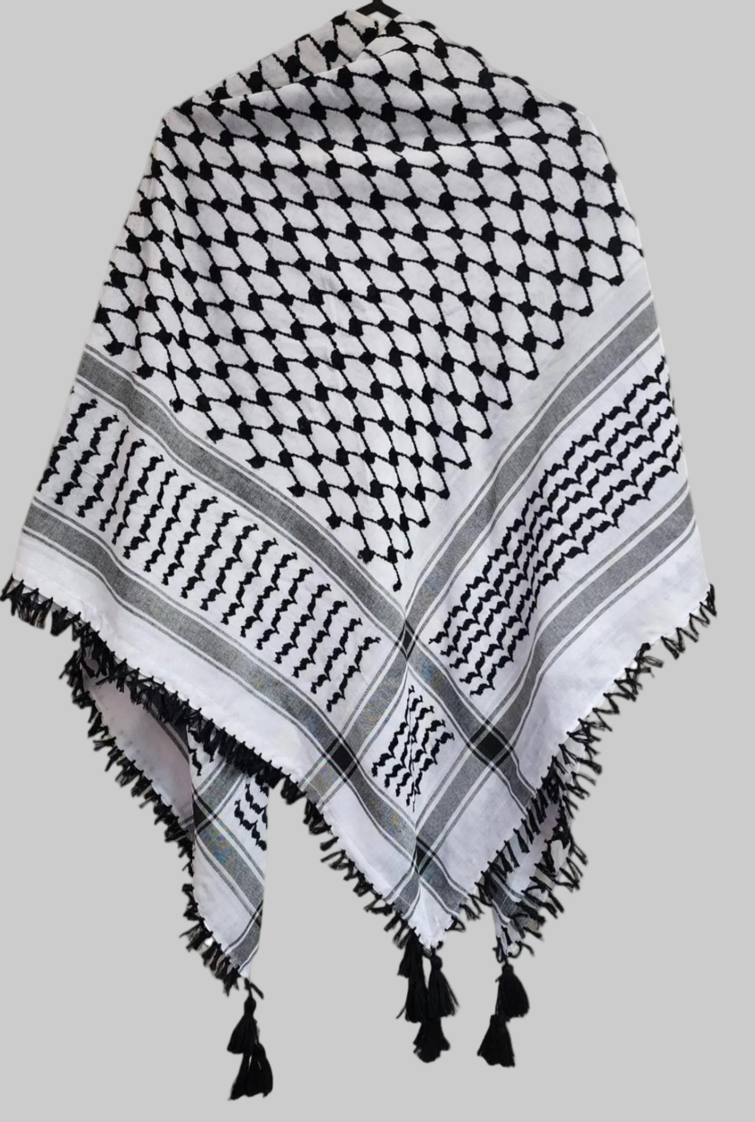 alt="Black and white Palestinian keffiyeh scarf laid flat showing traditional woven pattern"