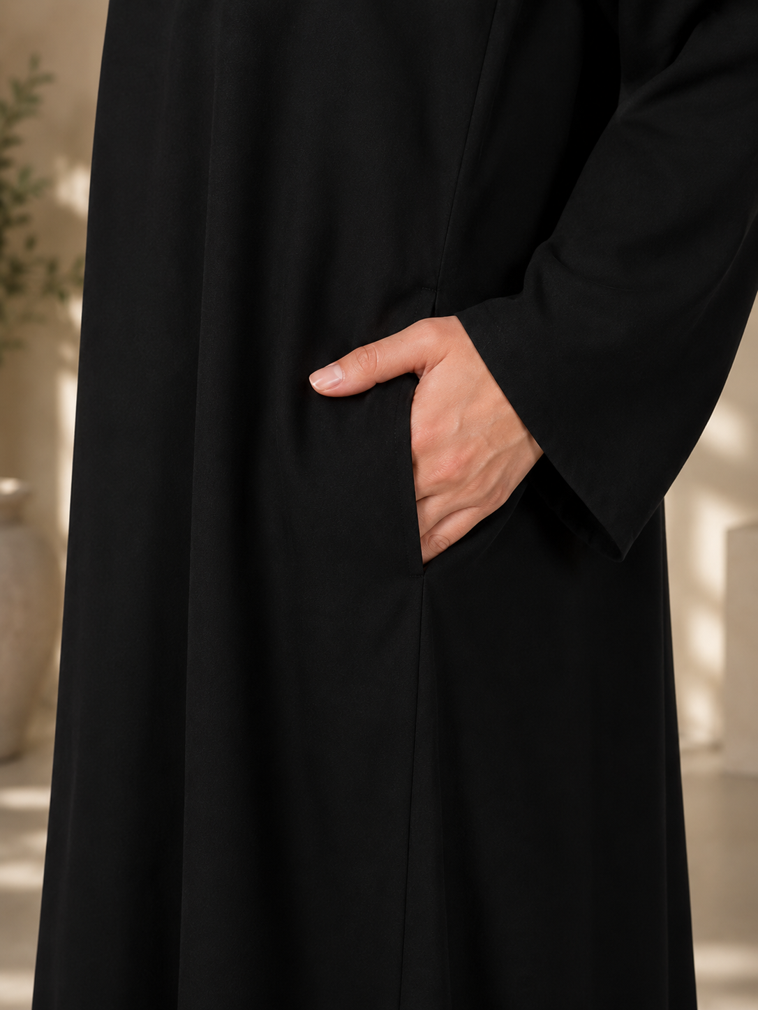 Close-up of side pocket detail on black essential nida abaya with flowing nida fabric