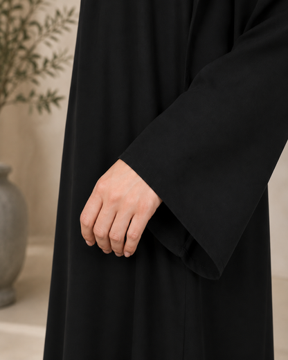 Close-up sleeve detail of black essential nida abaya showing wide cuff and soft nida fabric texture