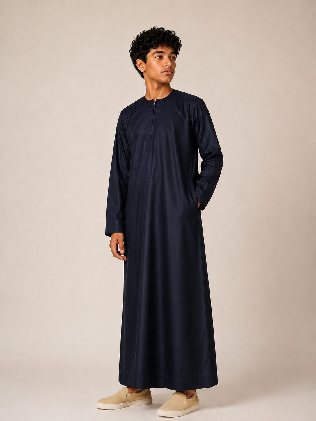 Boy wearing a premium Omani thobe in midnight navy with a traditional Omani neckline, front zip detail and elegant tailored finish.