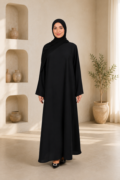 Woman wearing a black abaya in a room with shelves and plants