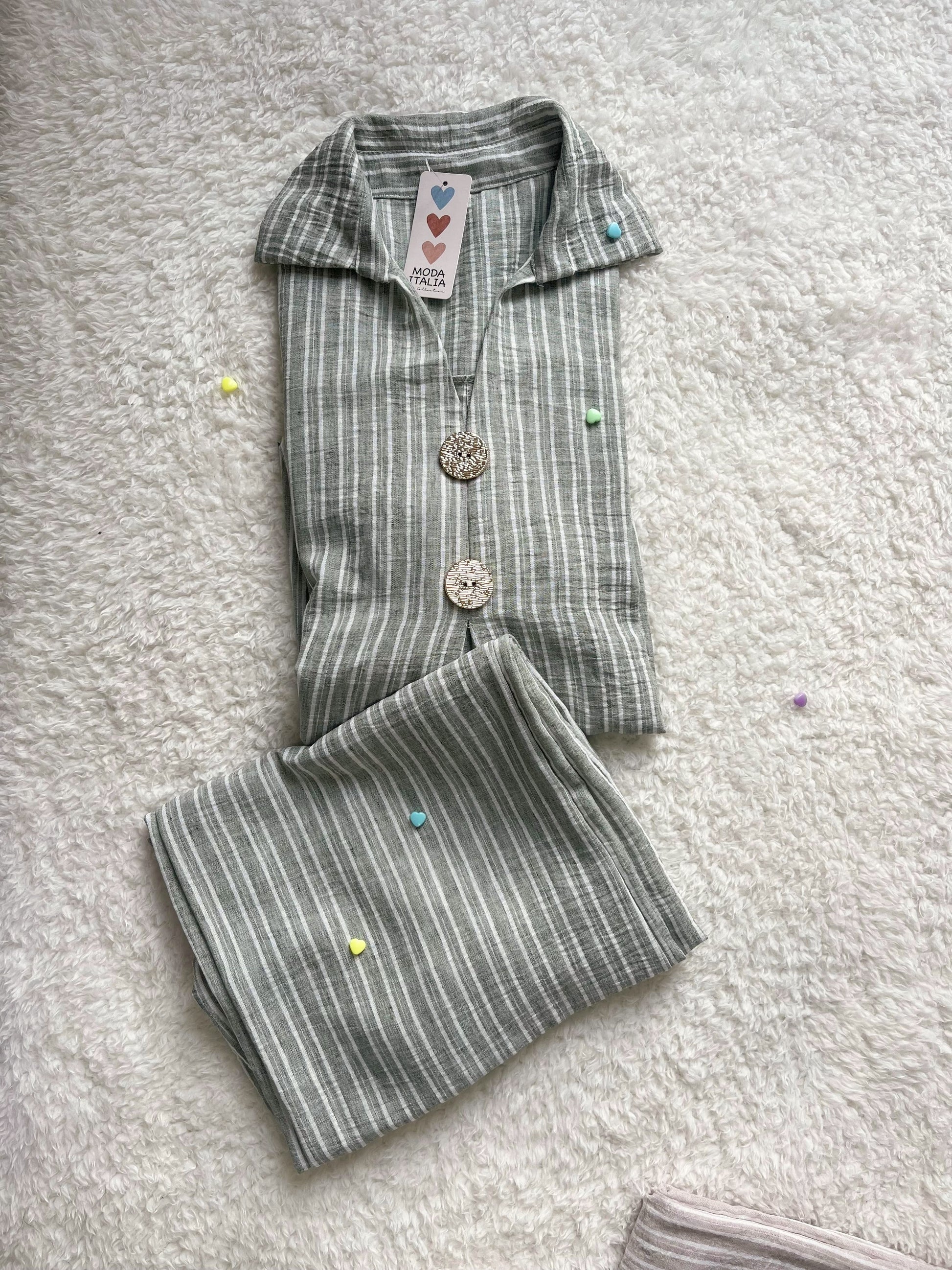 Woman wearing sage green linen co ord set with longline shirt and wide-leg trousers