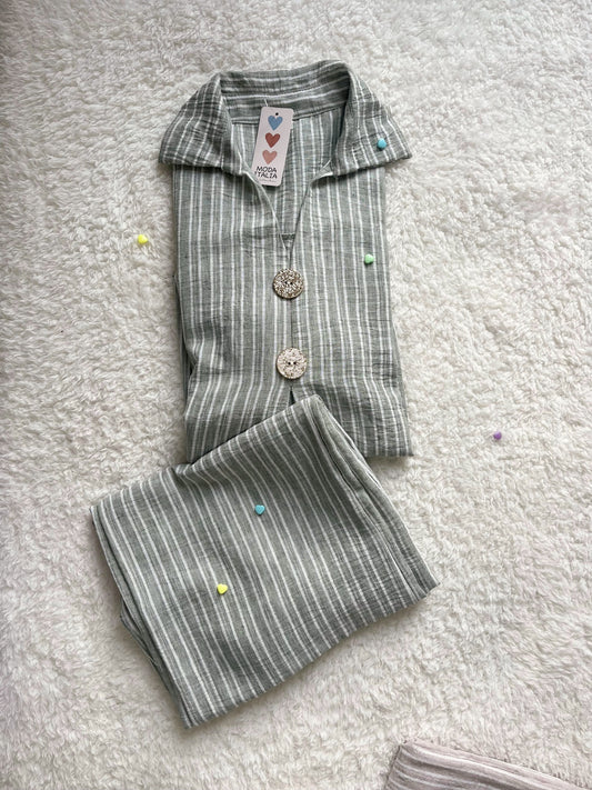 Woman wearing sage green linen co ord set with longline shirt and wide-leg trousers